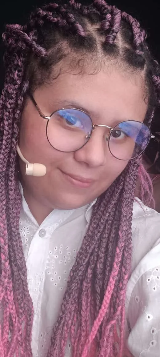 Julia Bueno — Park Juju com microfone headset e tranças coloridas