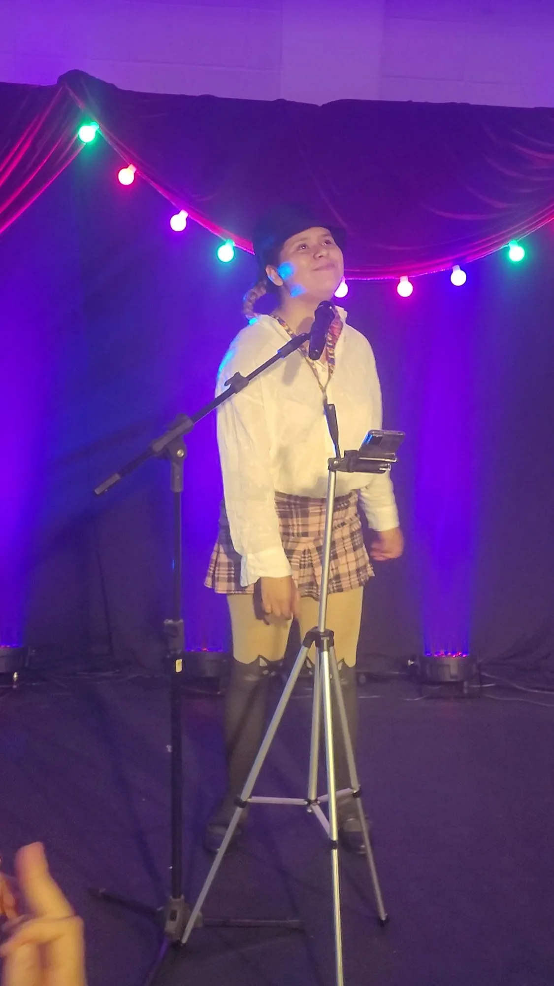 Julia Bueno se apresentando no palco com luzes coloridas — BERA